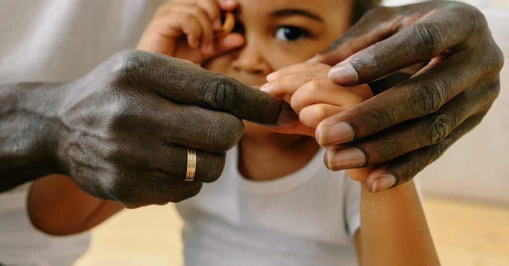 A close-up of a father holding his child's hand, symbolizing love and connection.