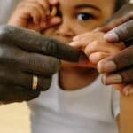 A close-up of a father holding his child's hand, symbolizing love and connection.