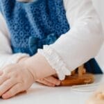 A young child playing with wooden educational toys indoors, fostering creativity and learning.