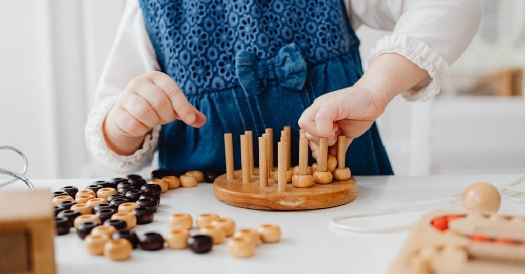 A child interacts with a wooden sorting toy, developing fine motor skills and learning through play.