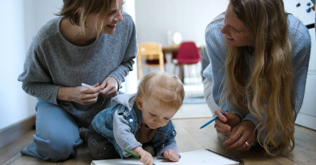 A heartwarming moment of two women and a baby drawing together indoors, symbolizing family bonding.