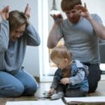 A joyful family moment with parents and baby drawing together on the floor, capturing precious memories.