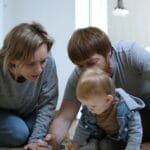 Parents and child drawing together indoors in a cozy Portuguese home.