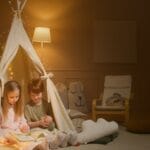 Two children enjoy a bedtime story inside a cozy indoor tent, creating a warm and inviting atmosphere.