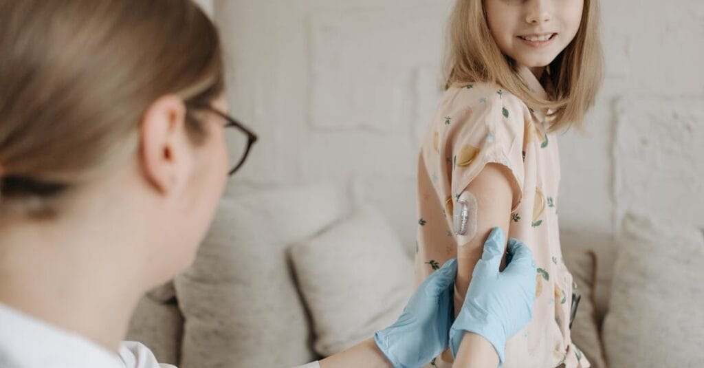 A young girl receives an insulin checkup from a medical professional at home, managing diabetes.