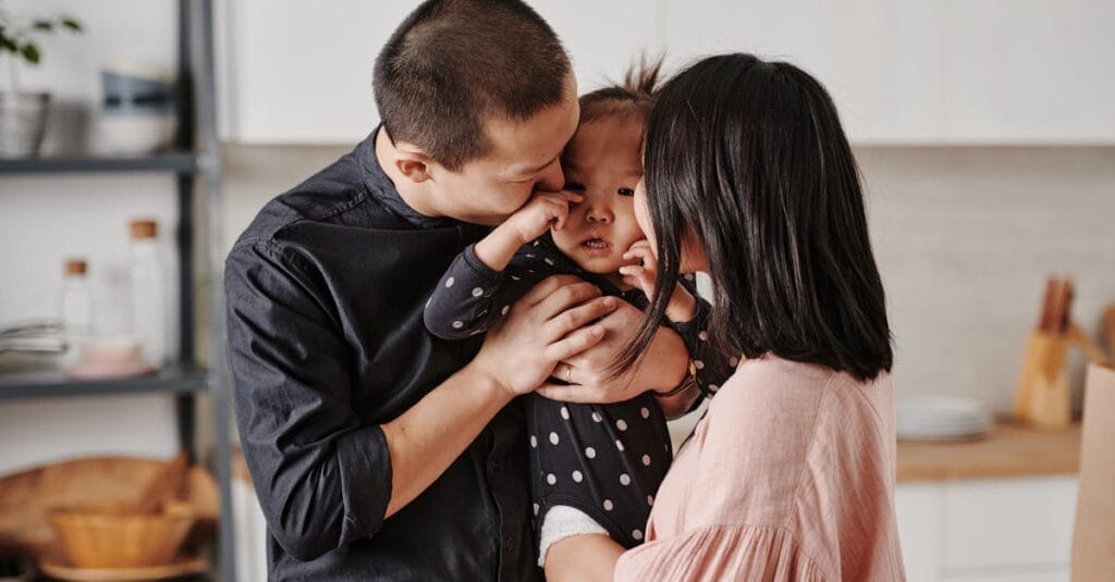 A loving Asian family shares a tender moment in their modern kitchen.