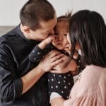 A loving Asian family shares a tender moment in their modern kitchen.