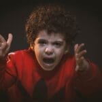 A young child expressing strong emotions during a studio portrait shoot.