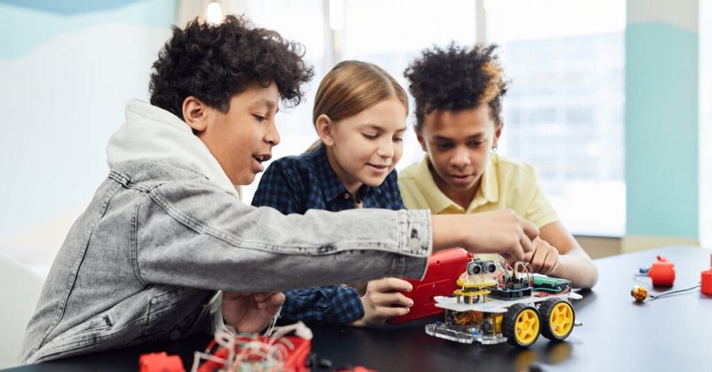 Children collaborating on an electronic robotics project, fostering teamwork and innovation.