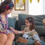 Mother and child sharing a tender moment with a gift on a cozy couch setting.