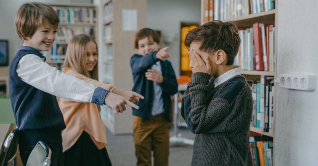 Group of children bullying a classmate in a school library setting.