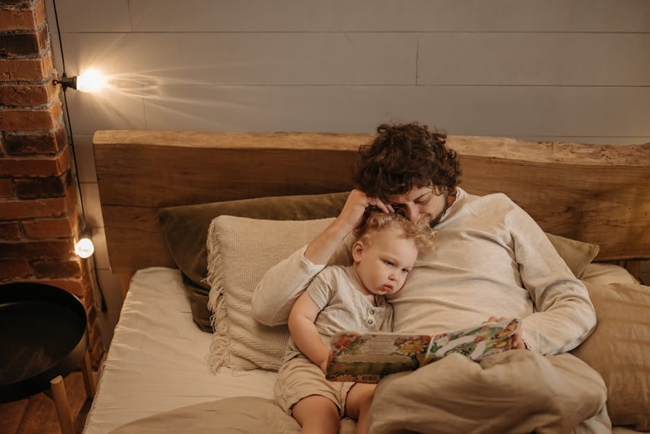 A father and child enjoy quality time reading a bedtime story in a cozy bedroom setting.