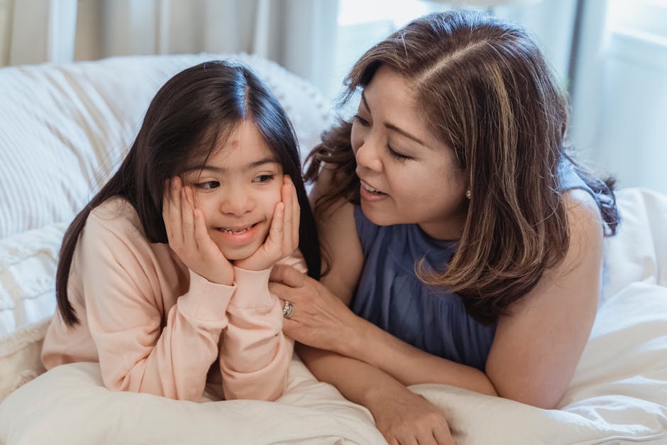 Tender moment between a mother and her daughter with Down syndrome, smiling in bed.