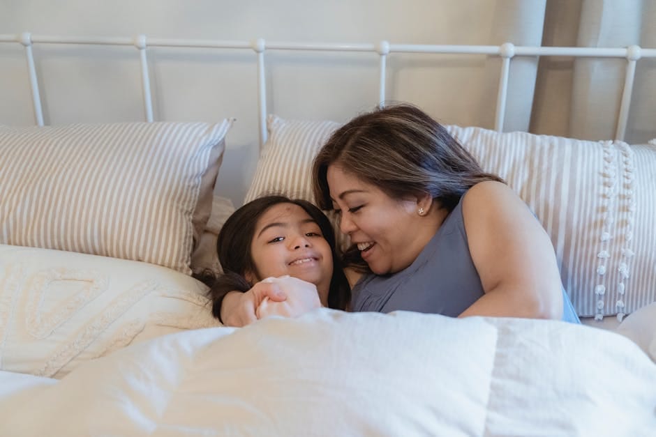A loving moment between mother and daughter in a cozy bedroom setting.