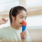 Young girl singing into a toy microphone, expressing joy and creativity indoors.