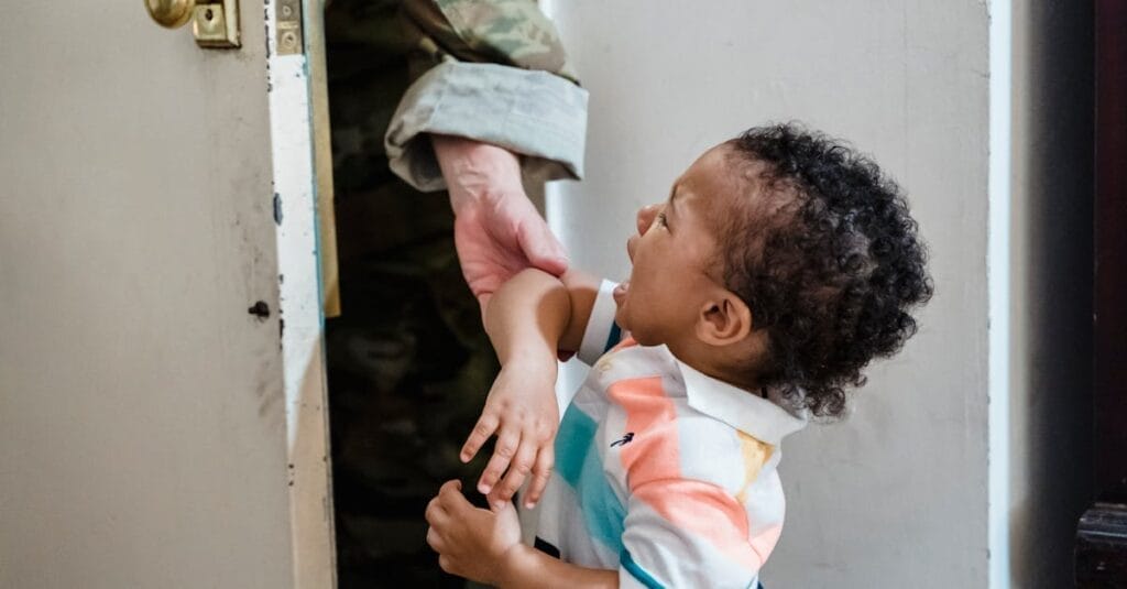 A young child crying as a soldier parent leaves, capturing emotional family moments.