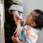 A young child crying as a soldier parent leaves, capturing emotional family moments.