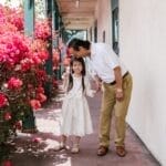 An elderly man affectionately kisses a smiling girl, symbolizing family love and togetherness.