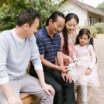 Family enjoying a sunny day in the park, sharing photos and creating memories.