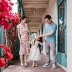 Asian family spending quality time outdoors, surrounded by vibrant flowers.