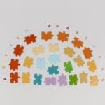 Colorful puzzle pieces arranged to promote autism awareness on a light background.