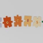 Colorful puzzle pieces spelling 'autism' on a white background, promoting awareness.