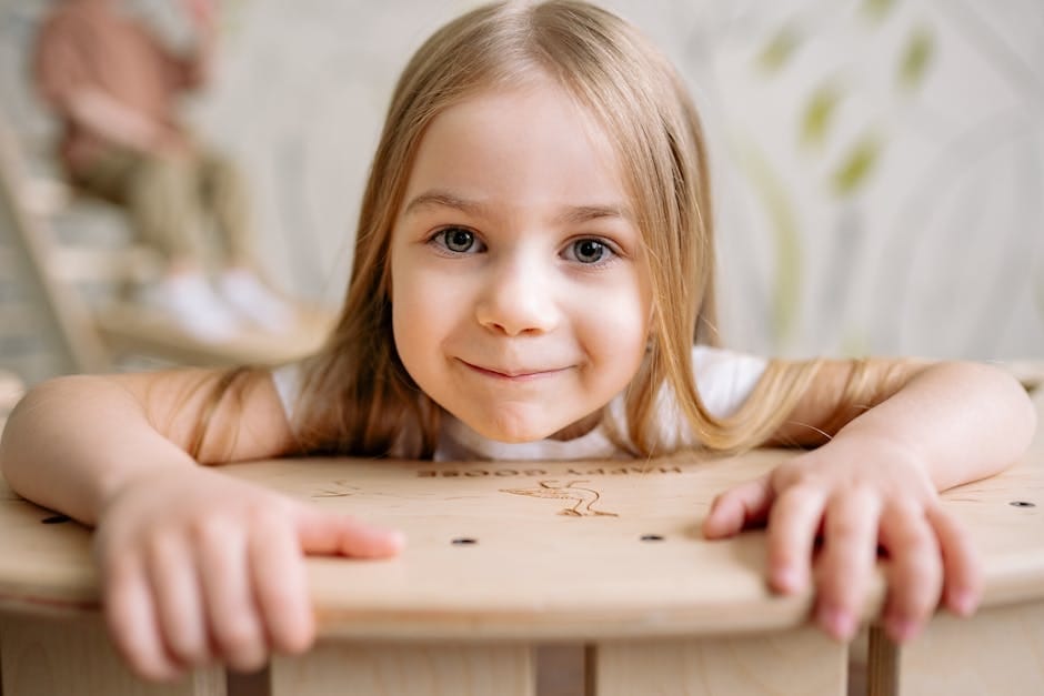 Close-up of a happy young girl smiling, showcasing innocence and joy in a bright setting.