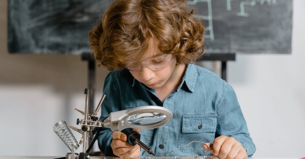 Young boy diligently working on a circuit board, exploring science and technology.