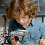 Young boy diligently working on a circuit board, exploring science and technology.