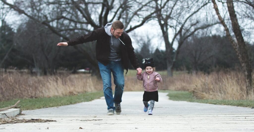 Dad and daughter enjoying a walk in the park, symbolizing love and togetherness.