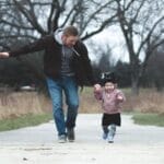 Dad and daughter enjoying a walk in the park, symbolizing love and togetherness.