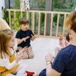 Teacher and children counting together in a bright indoor classroom setting.