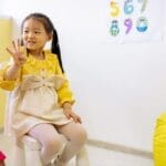 Young girl in a classroom setting learning numbers, showcasing educational activities.