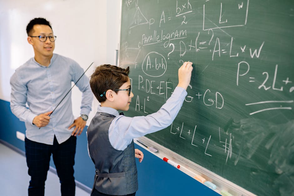 A teacher guides a student solving math equations on a classroom chalkboard.