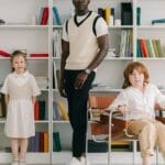 Family portrait featuring two children and an adult in a contemporary library setting with colorful bookshelves.