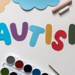 A vibrant autism awareness theme with watercolor paints and cutouts, featuring the word 'Autism'.