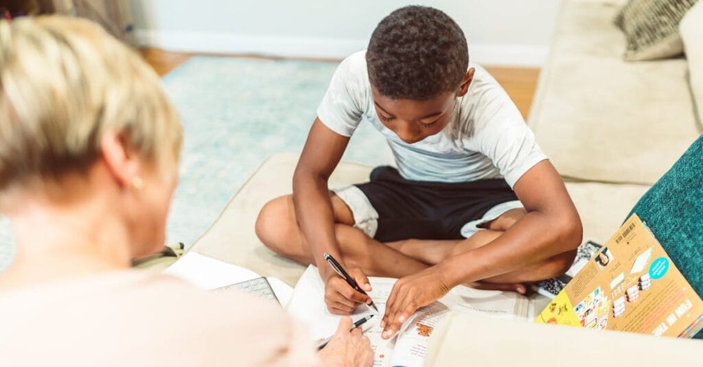 A child engaged in study at home with an adult, showcasing home learning and education