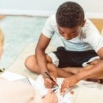 A child engaged in study at home with an adult, showcasing home learning and education