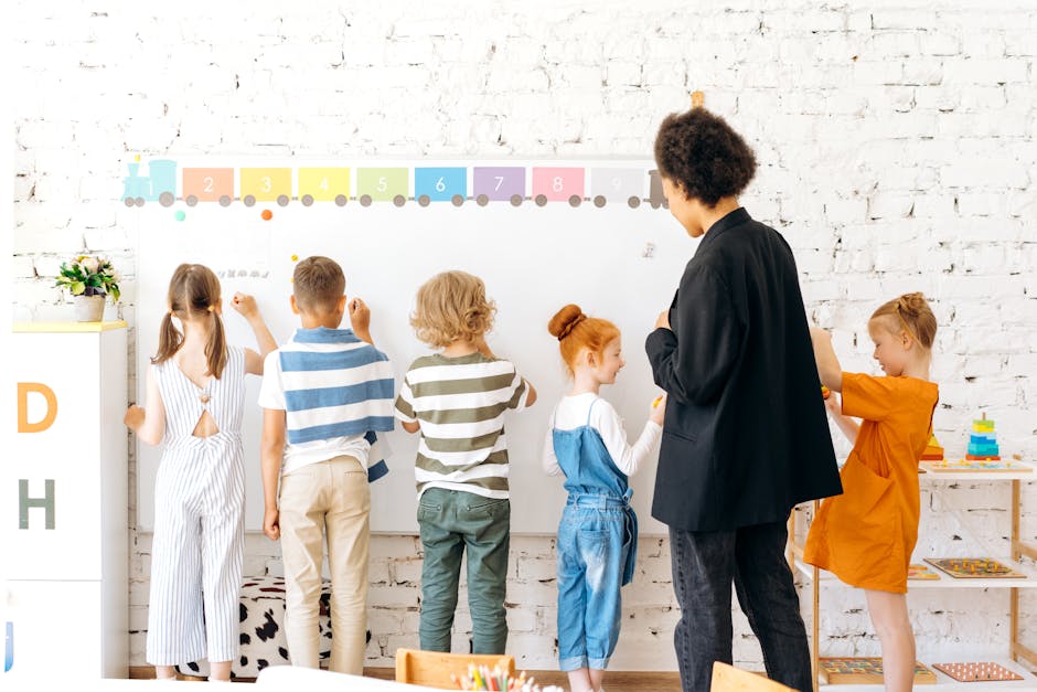 Group of children and teacher interacting with a whiteboard in a bright, indoor classroom setting.