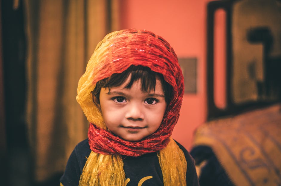 Charming portrait of a little boy in a colorful traditional scarf indoors. Perfect for themed visuals.