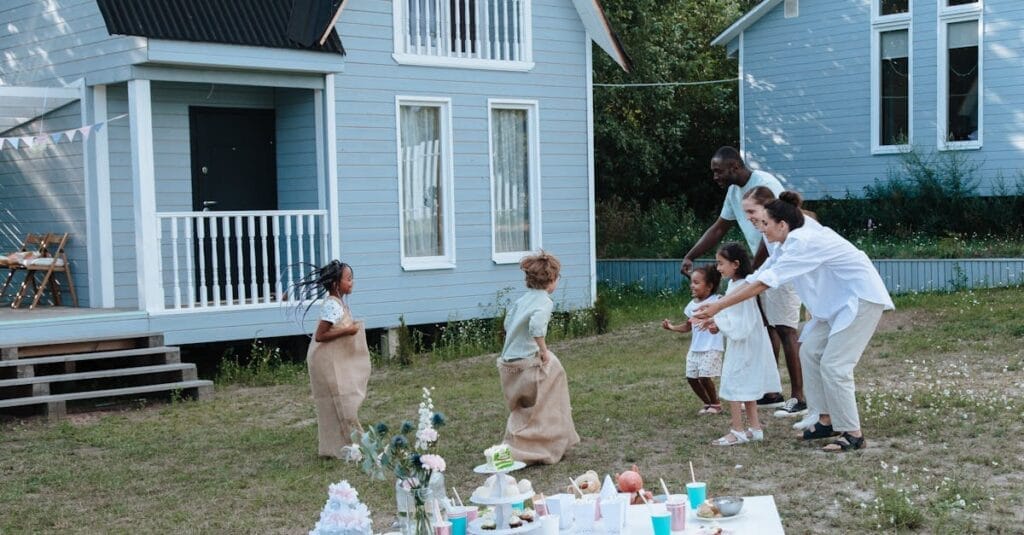 Children enjoying a sack race with parents cheering in a backyard garden.