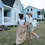 Children and adults enjoying a lively sack race in the yard during a family celebration.