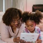 A mother and daughter enjoying a bedtime story, fostering togetherness and literacy.