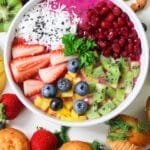 Vibrant smoothie bowl topped with assorted fresh fruits and muffins, perfect for a healthy snack.