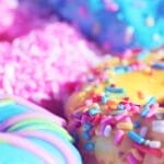 Close-up of assorted donuts with colorful icing and sprinkles, showcasing sweet indulgence.