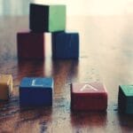 A vibrant still life of wooden alphabet blocks spelling 'PLAY' on a wooden surface.