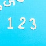 Creative layout of white numbers on a bright blue background, focusing on '123'.