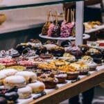 A tempting display of various donuts and pastries in a bakery. Ideal for food lovers and culinary enthusiasts.