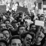 Crowded Algerian street protest captured with intensity and detail.