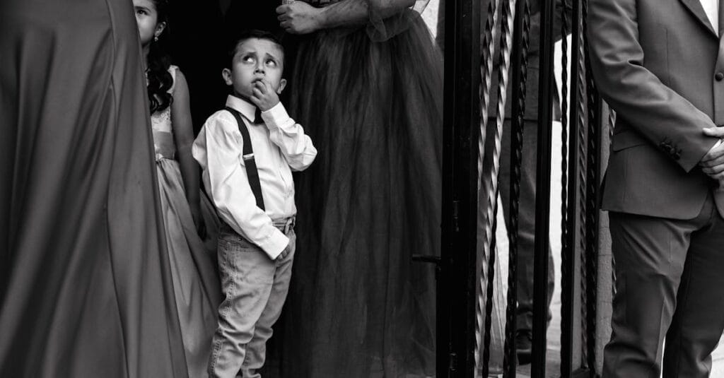 A thoughtful moment captured in black and white during an elegant event with children and adults.